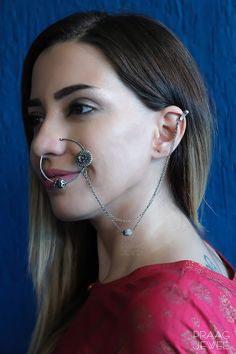 a woman with piercings on her nose and nose chain