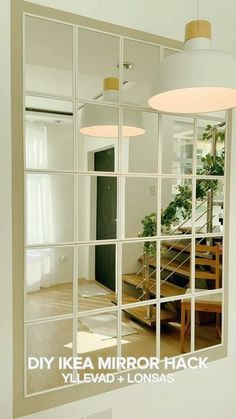 a mirror that is on the wall in front of a table and stairs with plants