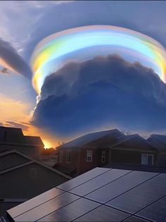 a rainbow in the sky over some houses