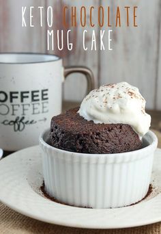 a chocolate mug cake with whipped cream on top and coffee cup in the back ground