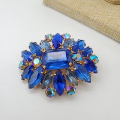 "Vintage blue brooch made in Czechoslovakia. There are light blue and electra blue rhinestones accented by Aurora Borealis round crystals. This brooch is in excellent vintage condition. Dimensions: 1.75\" by 2\"." Floral Baskets, 1930s Art Deco, Moon Glow, Blue Rhinestones, Vintage Pins, Aurora Borealis, Vintage Signs, Vintage Brooches, Aurora