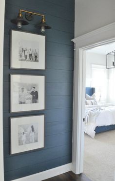 a bedroom with blue walls and pictures on the wall