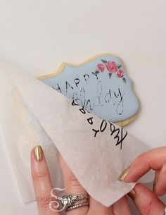 a person holding a piece of paper with the words happy birthday on it