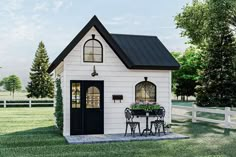 a small white house sitting on top of a lush green field next to a fence