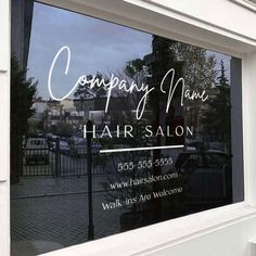 a hair salon window with the reflection of cars in it's glass front door