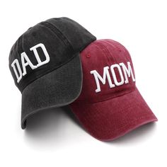 two baseball caps with the words dad and mom printed on them, one black and one red