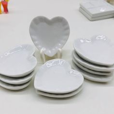 a stack of white heart shaped plates sitting on top of a table