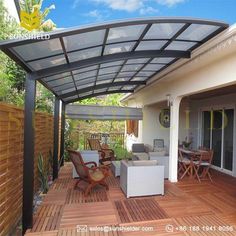 an outdoor covered patio area with furniture and wood flooring on the outside side of the house