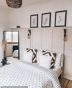 a bed with white and brown sheets in a bedroom next to pictures on the wall