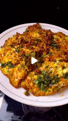 a white plate topped with an omelet covered in cheese and spinach leaves