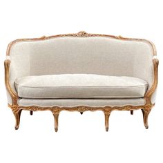 an antique style couch with gold trimmings and white upholstered fabric on the back