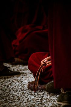 a group of people sitting on the ground with beads in their hands