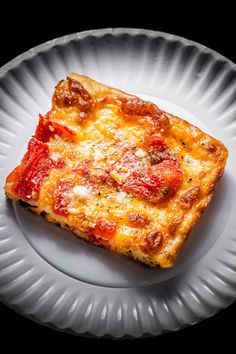 a piece of pizza sitting on top of a white plate