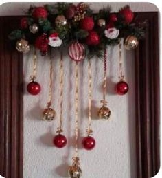 christmas decorations hanging on the wall in front of a mirror with red and gold ornaments