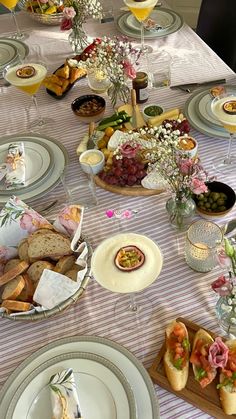 the table is set with plates, bowls and glasses for food to be eaten on