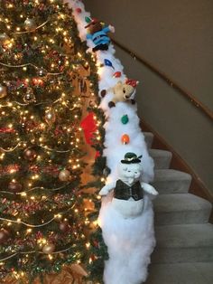 a christmas tree with teddy bears on it next to a staircase decorated for the holiday season