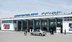 an airport with people walking around and cars parked outside