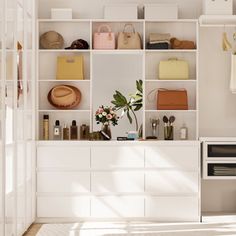 a white closet filled with lots of different types of purses and handbags on shelves