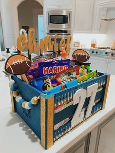 a football themed candy chest on a kitchen counter with personalized items in the bin