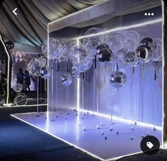 balloons and streamers are suspended from the ceiling in front of an illuminated display case