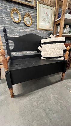 a black bench with pillows on it in a room