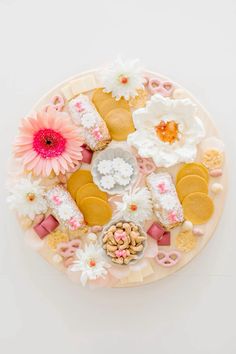 a platter filled with lots of different types of cookies and flowers on top of it