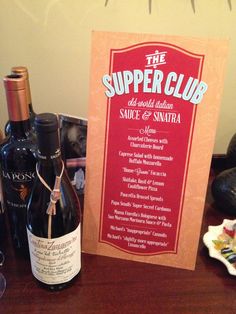 there is a wine bottle on the table next to a sign that says the supper club