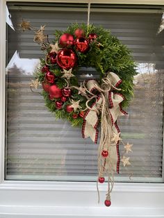 a christmas wreath hanging on a window sill