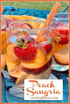 peach sangria with strawberries and oranges in glasses on a blue tablecloth