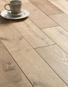 a cup and saucer sitting on top of a wooden floor