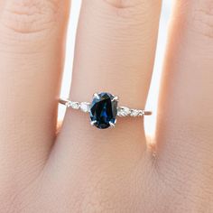 a woman's hand with a blue and white diamond ring