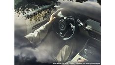 a person sitting in the driver's seat of a car with their hands on the steering wheel