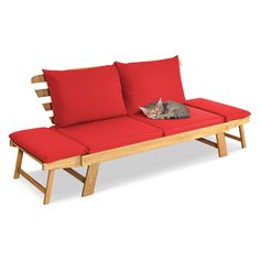 a cat laying on top of a wooden bench with red cushiones and matching cushions