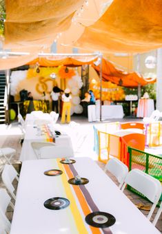 an outdoor event with tables and chairs set up