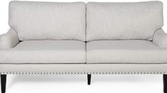 a white couch with studding on the arms and backrests, sitting in front of a white background