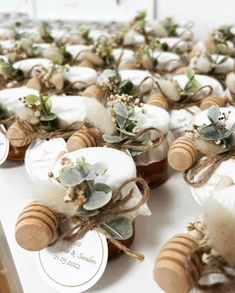 several honey jars with flowers on them are sitting on a white tablecloth covered table