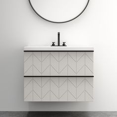 a bathroom vanity with a round mirror above it and a black faucet on the wall