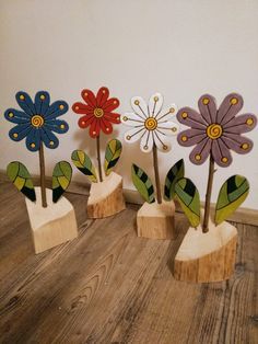 four wooden flowers are sitting on the floor