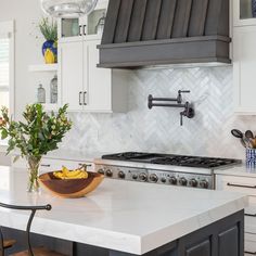 a kitchen counter with a bowl of bananas on it and a potted plant in the middle