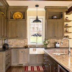 a large kitchen with wooden cabinets and marble counter tops, along with an area rug on the floor