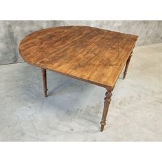 an old wooden table sitting on top of a cement floor