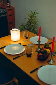 the table is set with plates, silverware and candles for two people to enjoy