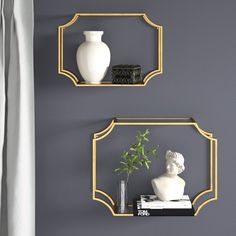 two gold framed mirrors on the wall above a shelf with vases and other items