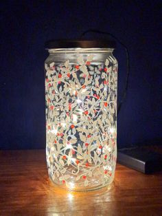 a glass jar with lights in it sitting on a table