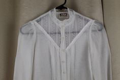 "Rare Childs/Girls white blouse Gunne Sax Jessica's Gunnies Blouse has double layer but single layer on sleeve Lace trim on sleeves and sheer lace insert on blouse with classic Gunne Sax satin ribbon detail We are not great on childs sizes so please use measurements below. We think this is a size 10 Girlss/child Pearl buttons Good condition Missing one button on one cuff See photo #7. Has been sewn closed. Very light fading Hand washed and ready to wear! Measurements Underarm to underarm: 15.5\" Heirloom Dresses, Gunne Sax, Girls Blouse, Lace Insert, Pearl Buttons, White Blouse, Fire Emblem, Sheer Lace, Satin Ribbon