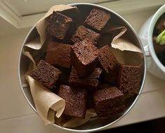 a bowl filled with brownies next to a bowl of broccoli