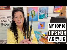 a woman holding two paint brushes in front of her face with the words my top 10 tips for acrylic