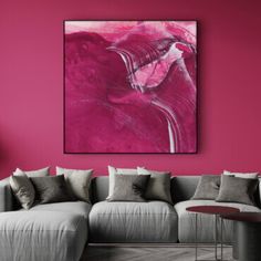 a living room with pink walls and grey couches in front of a painting on the wall