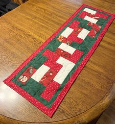 the table runner is made with red and green fabric, along with santa's sleighs