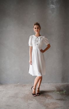 "This design linen dress is perfect for summer and fall! 100 % designed and handmade by Emsilk. I am pleased to offer your garments made to measure at no extra cost. * Detail: - Collared neckline - Coconut buttons on the front - Small gathered decoration on the front - Fit and flare bottom - Fully lined - Invisible zipper on the back - Below the knee length - High quality linen, washed linen, soft linen - The model is 5'6\" tall and wearing size S. * Care: - Dry clean or machine washed with cold White Puff Sleeve Vintage Dress For Summer, Puff Sleeve Vintage Dress For Summer, Short Sleeve Fitted Linen Dress For Day Out, Feminine Puff Sleeve Dress For Daywear, A-line Short Sleeve Dress For Summer Daywear, Spring Mid-length Linen Dress For Daywear, Spring Daywear Mid-length Linen Dress, Chic Fitted Linen Dress With Puff Sleeves, Chic Short Sleeve Linen Dress